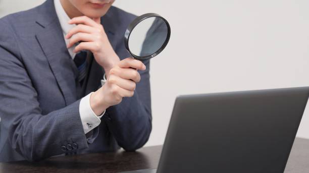 istock Businessman investigating with a magnifying glass 2174091185