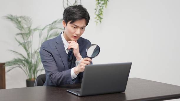 istock Businessman investigating with a magnifying glass 2174091197