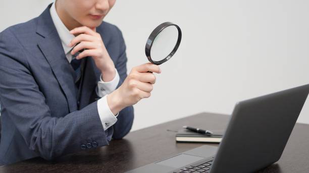 istock Businessman investigating with a magnifying glass 2174091209