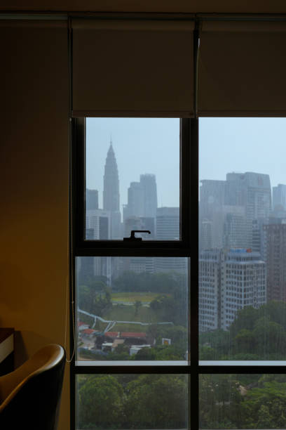 Interior of a working desk with urban skyline window view during blue hour. Modern living.