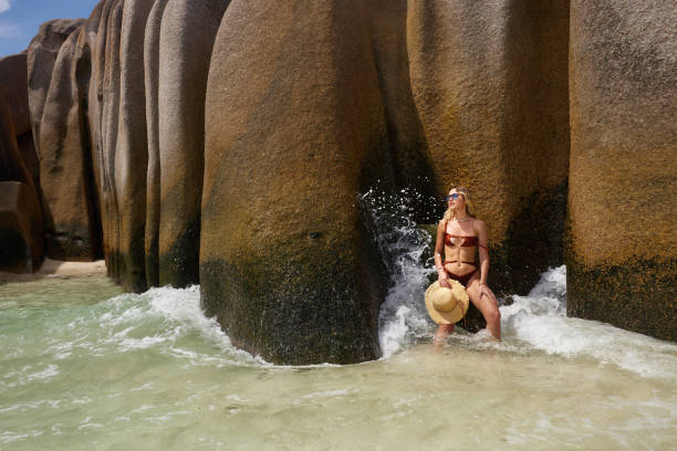 istock Sensual woman spending a summer day in sea at Anse Source d'Argent beach. 2174094410