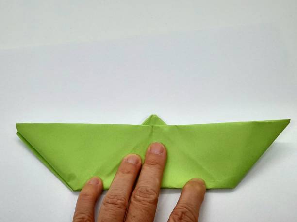 istock One green paper ship in hand 2174095970