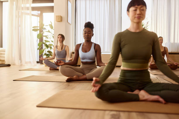 istock Athletic women doing meditation exercises at Yoga studio. 2174098446
