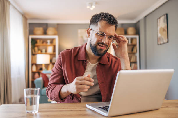 istock A mid adult man suffering from a headache. is using her laptop at home 2174101990