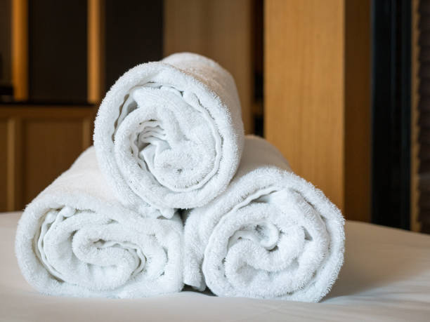 istock Rolled white bath towels on top of bed. 2174103356
