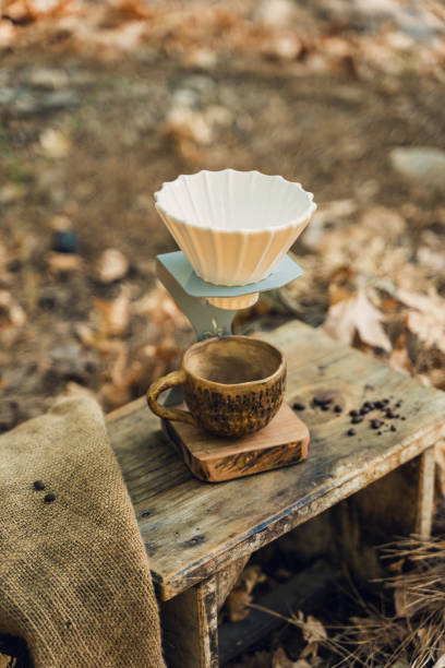 istock Ceramic Coffee Filter and Mug Set on Wooden Table in Natural Setting 2174111026