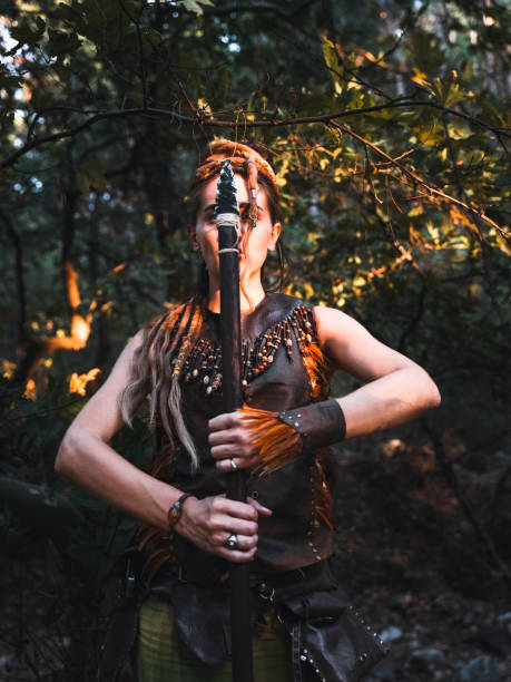 istock Warrior Woman Posing with a Staff in the Forest 2174111699