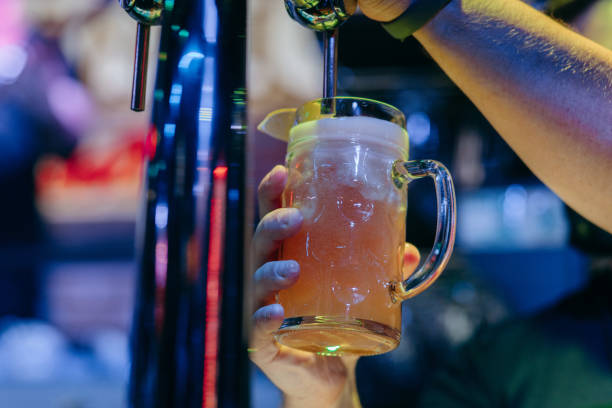 istock Bartender pouring beer at the bar. Close up hands 2174111714