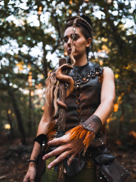 istock Warrior Woman Posing with a Staff in the Forest 2174111729
