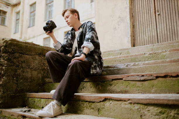 nice guy in a plaid shirt and a t-shirt with a camera in his hand model hobby studio. High quality photo