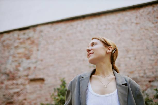 istock Smiling Woman Standing Outside With Brick Wall Background 2174114455