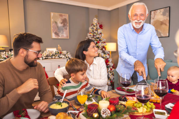 istock Senior man cutting chicken for family Christmas dinner 2174114535