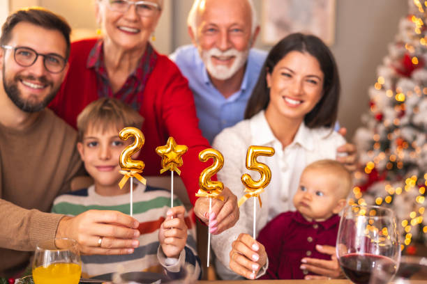 istock Multi-generation family holding balloons shaped as numbers 2025 while having Christmas dinner 2174115155