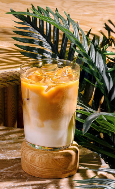 istock Iced latte resting on a wooden surface with tropical plants 2174116645