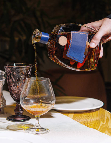 istock Waiter pouring cognac into glass on restaurant table 2174117167