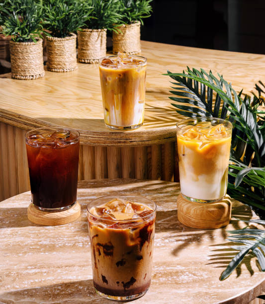istock Four iced coffee drinks sitting on a cafe table in the sun 2174119839