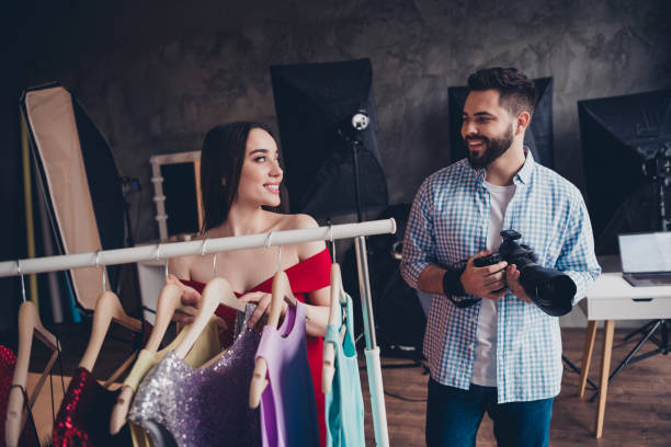 istock Handsome male stylist photographer working with model in studio help create outfit for magazine photo 2174120918