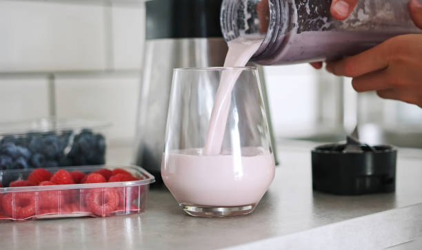 istock Little Girl Pouring A Raspberry Milkshake Into A Glass 2174122291