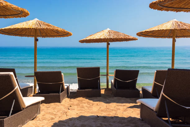 istock Summer beach scene with sunbathers and umbrellas 2174129592