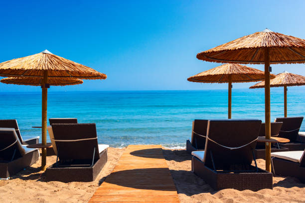 istock Summer beach scene with sunbathers and umbrellas 2174130195