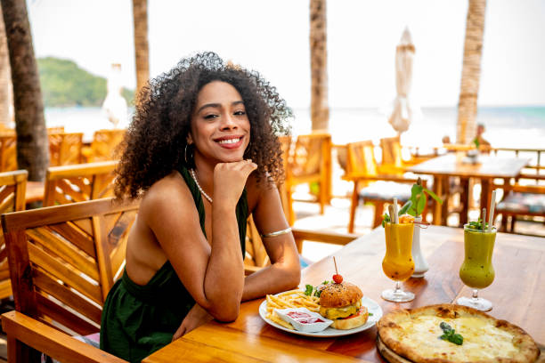 istock Smiling Woman Enjoying Lunch at Beachside Restaurant 2174132834