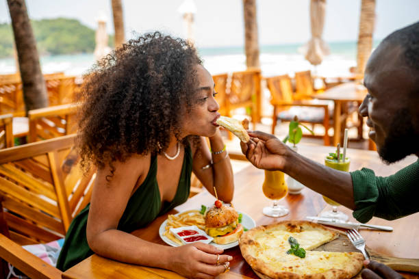 istock Couple Enjoying Pizza at Beachfront Restaurant on Sunny Day 2174132864