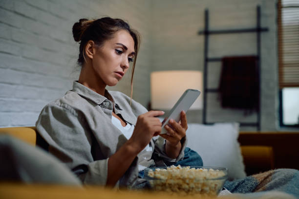 istock Young woman text messaging on cell phone in the evening at home. 2174137032