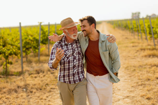 istock Two men stroll through a sunlit vineyard, sharing laughter and stories on a warm afternoon, surrounded by lush green vines 2174137628