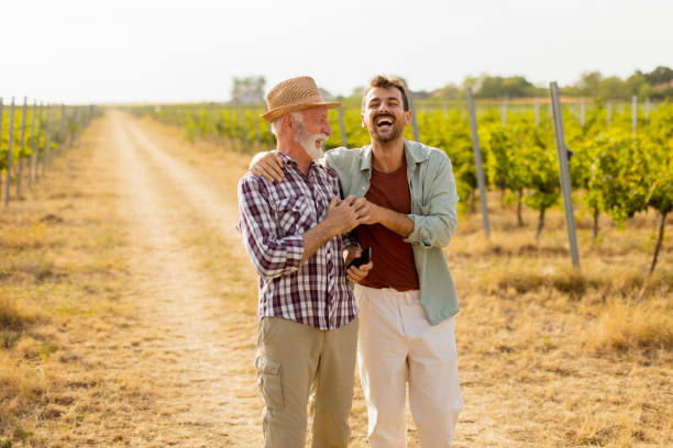 istock Two men stroll through a sunlit vineyard, sharing laughter and stories on a warm afternoon, surrounded by lush green vines 2174137683
