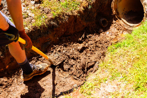 istock On construction site, worker digs trench with shovel in order to install a drainage pipe 2174137928