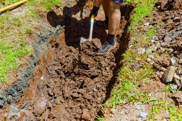 istock Worker digs trench for drainage pipe with a shovel 2174137933