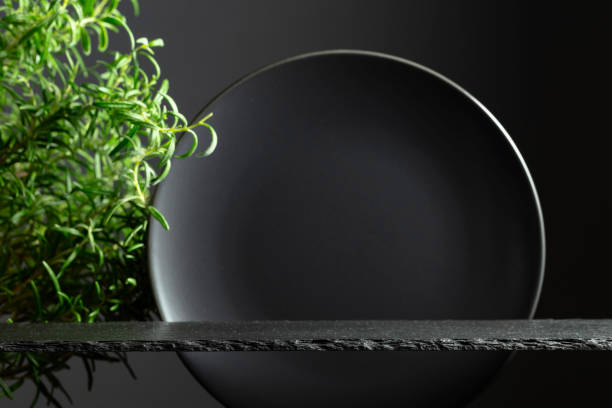 istock Black stone podium, black ceramic plate and branches of rosemary. 2174138554