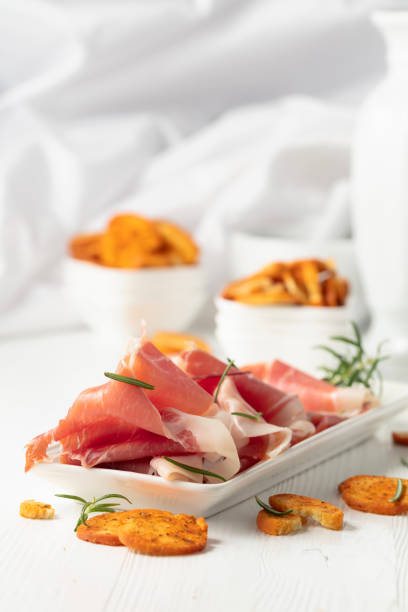 istock Prosciutto with rosemary and spicy bruschetta crackers. 2174138585