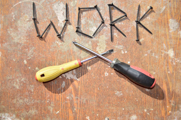 the word work made with black screws and yellow screwdriver crossing thee black screwdraver