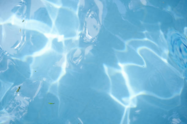 Surface of blue swimming pool, reflection on blue water, swirl pattern texture. Leaves in dirty water, opened swimming pool. Background, backdrop with copy space.