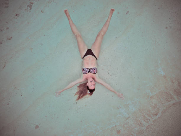 Female adult on a tropical beach posing, aerial bird's eye view image, Maldives