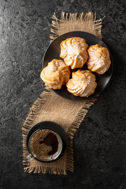 istock Cream cakes and black coffee on a black table. 2174145100