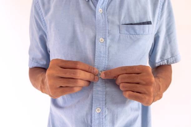 istock A man buttoning up his blue shirt, on a white background 2174146421