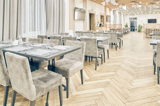 istock View of a large bright empty restaurant with tables, soft chairs and a wooden floor. Modern interior of a restaurant, cafe for events, holidays, weddings, birthdays with copy space 2174148416