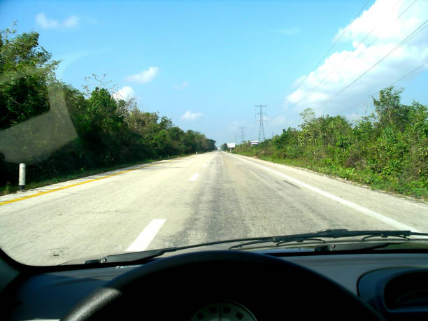 istock View out the front window of a car looking down a single lane highway in Mexico 2174149606