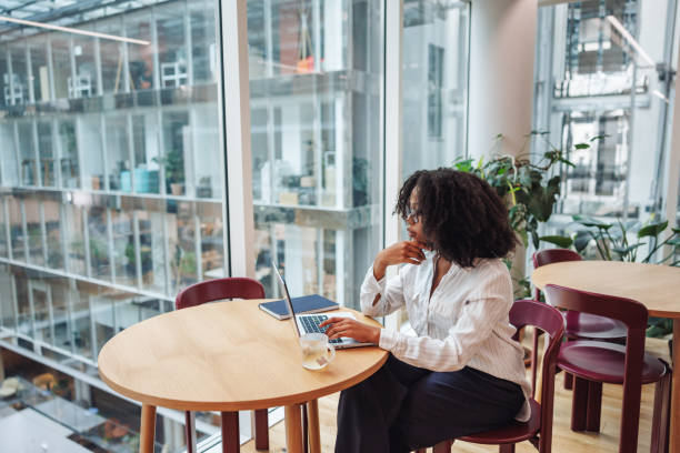 istock Professional Black Businesswoman Engaging in Work at Office Cafeteria 2174149818