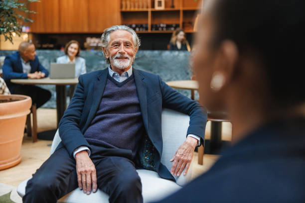 istock Experienced Businessman Engages in Discussion at Cafe Venue 2174150483