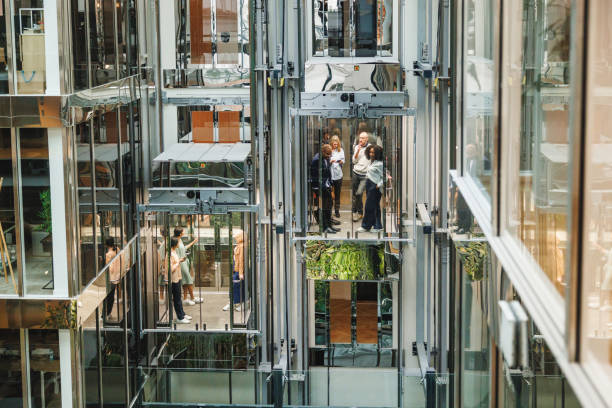 istock Diverse Executives in Glass Elevators at Corporate Tower 2174150527