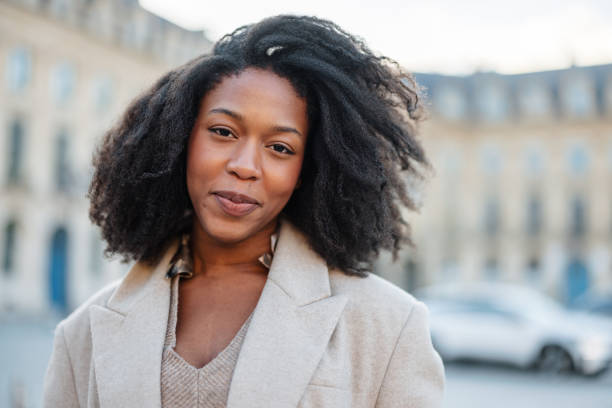 istock Young Black Woman Smiling Outdoors In Neutral Attire 2174152335