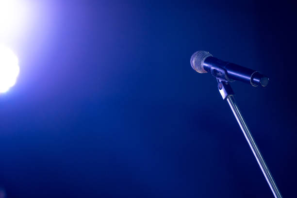 istock Close-up the microphone on stand for speaker speech at seminar room with blue light background and blur bokeh, Presentation microphone on a stand, Copy space 2174153158