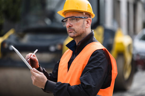 istock Construction site supervisor reviewing plans while wearing safety gear outdoors during daytime 2174153235