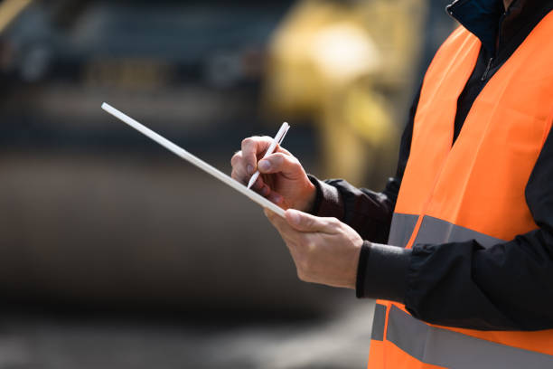 istock Construction worker in safety vest taking notes at a job site during daylight hours 2174154603
