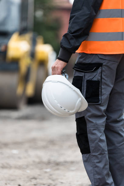 istock Construction worker in high-visibility vest holding hard hat at a worksite during daylight hours 2174155516