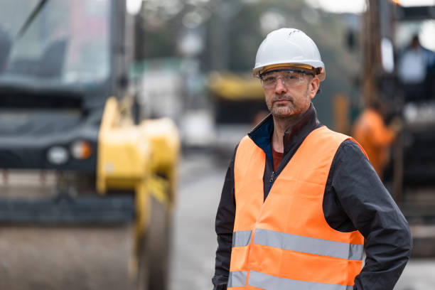istock Construction worker in safety gear oversees roadwork at a construction site during daytime hours 2174155922