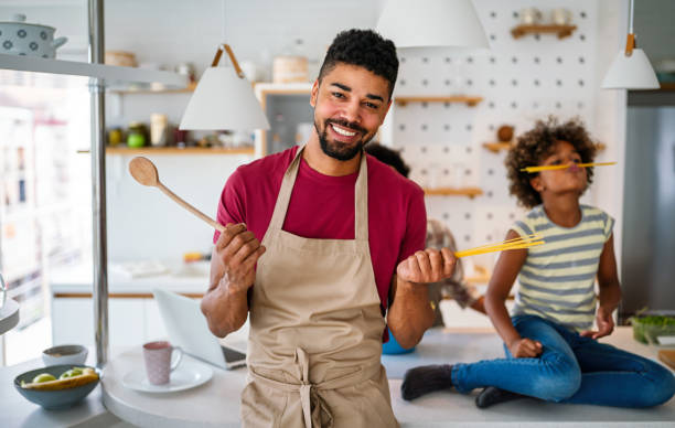 istock Cheerful smiling black father playing with his daughter in kitchen at home. Single Dad Lifestyle 2174159225